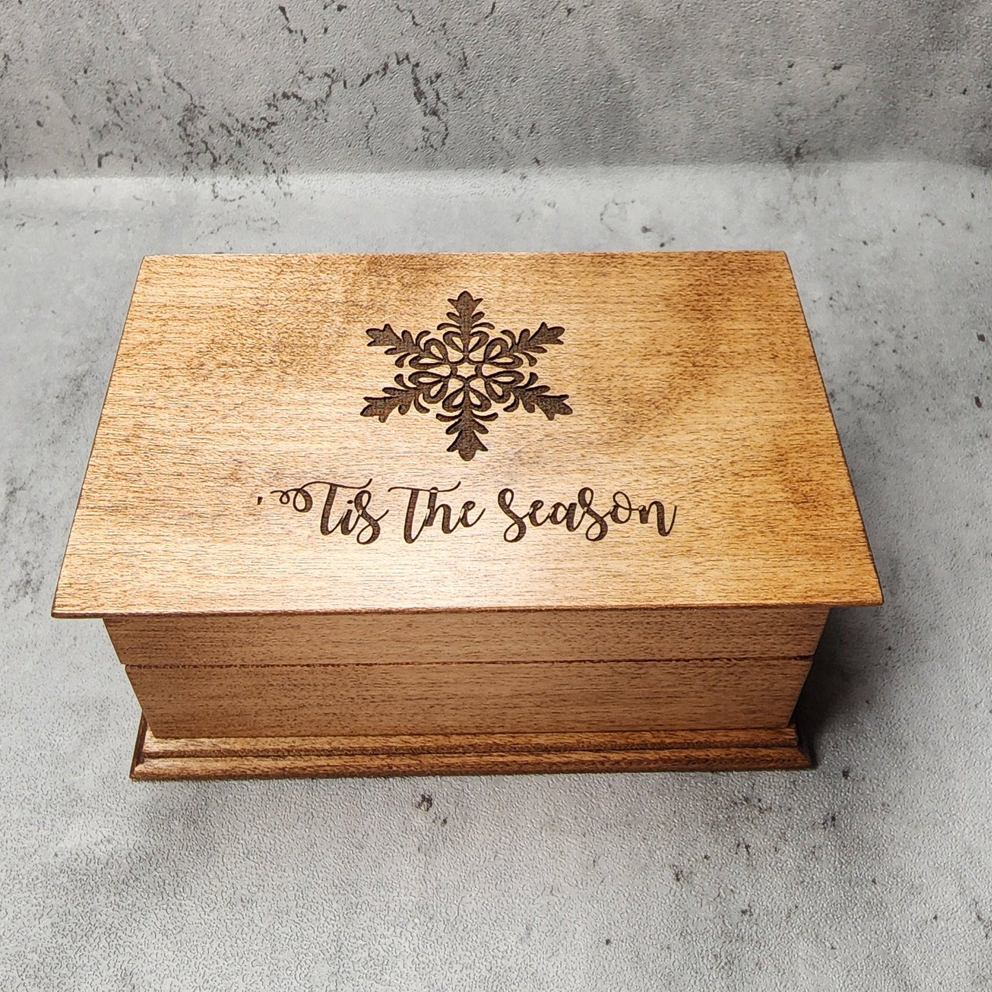 Handmade holiday keepsake box displayed beside festive greenery