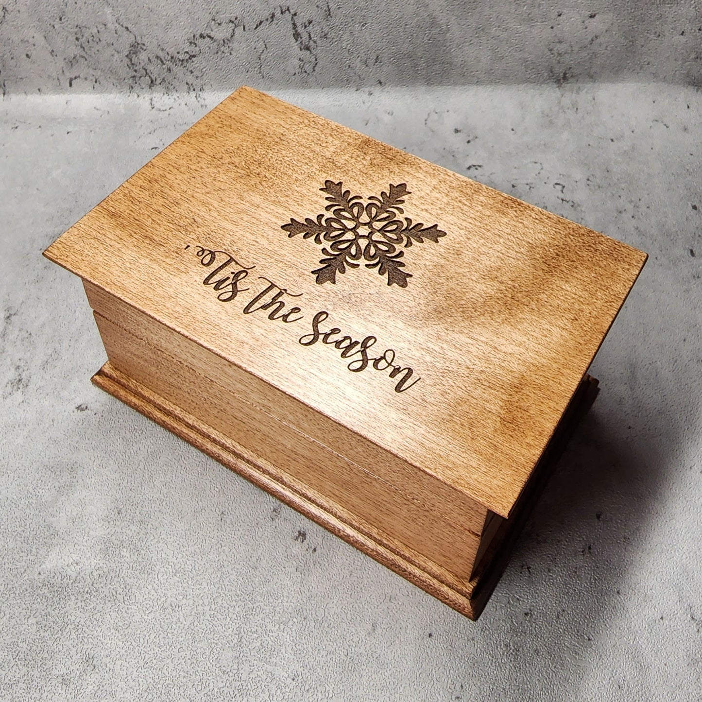 Wooden music box with snowflake engraved on top with 'tis the season