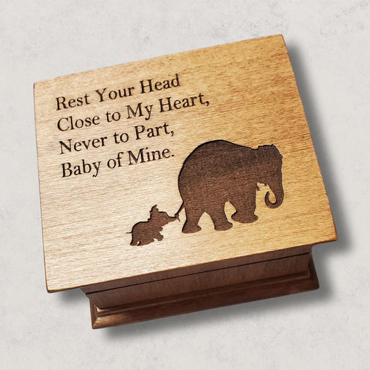 small wooden music box in chestnut with a momma and baby elephant silhouette engraved on the top along with the quote Rest Your Head Close to My Heart.... , choose the song Baby Mine and create a one-of-a-kind keepsake
