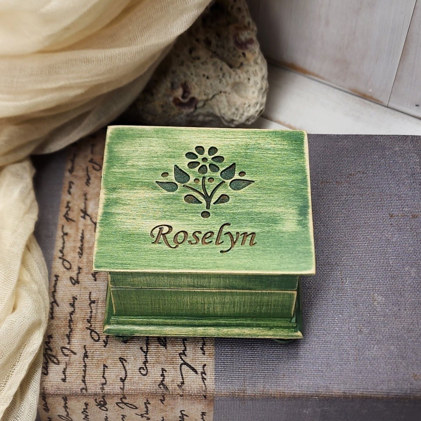 Green wooden box with 'Roselyn' engraving on a textured surface