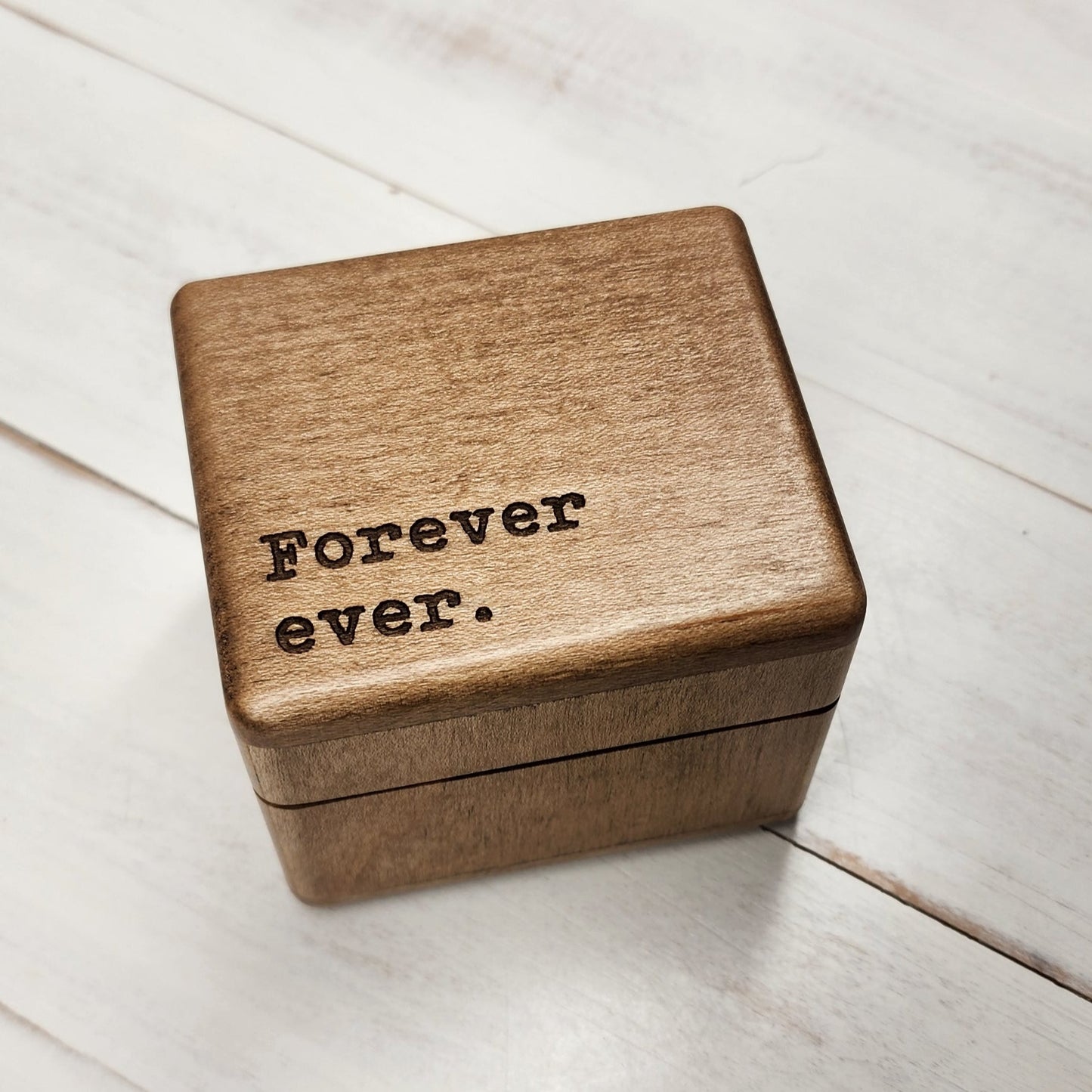 Wooden Ring Box engraved with Forever ever in the lower left corner. It has a built-in music player under the lid and a felt ring insert inside to hold the ring safely.