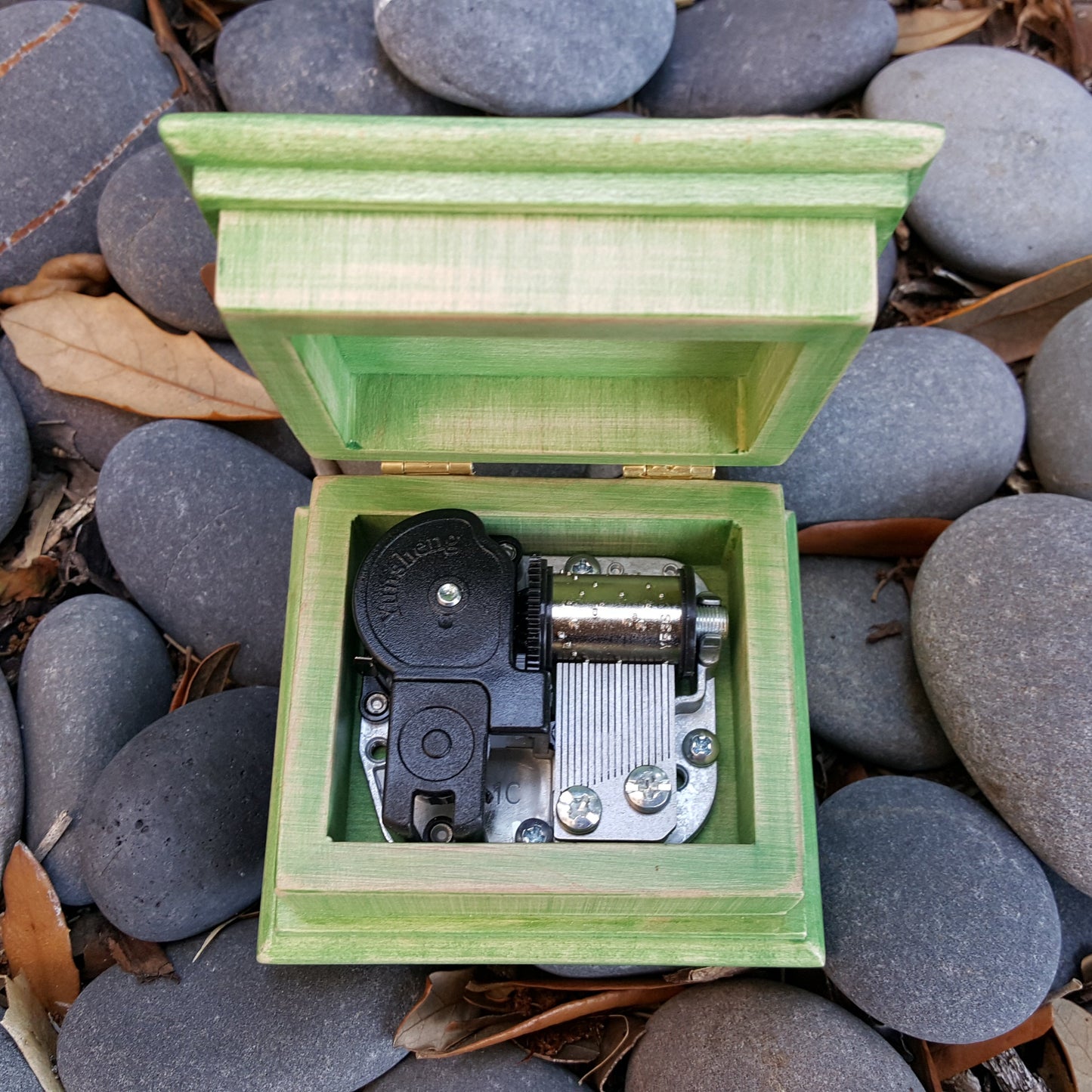 rocky background with a green wind up music box