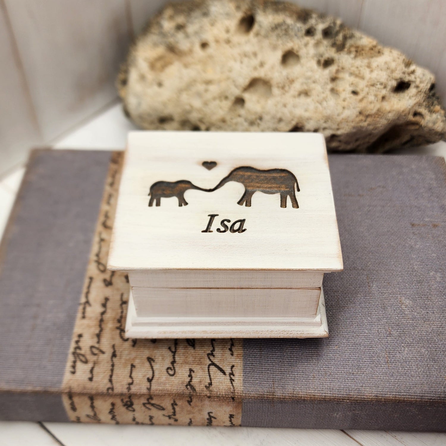 wooden music box with vintage white paint, it has a name and a baby and momma elephant engraved on top, choose song, color, add a personalized message to the bottom side of box