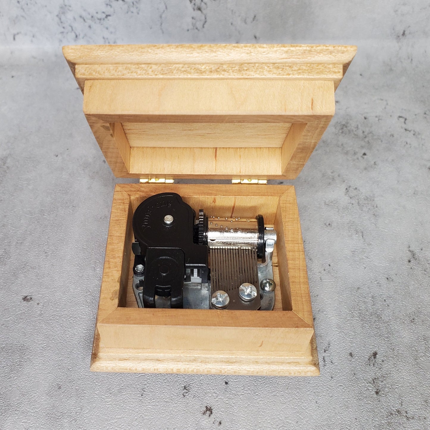 music box with open lid showing engraving on top