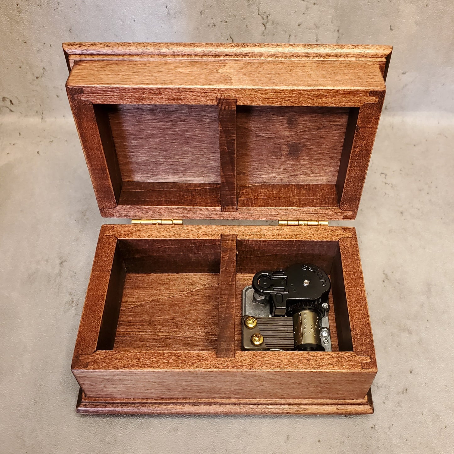 music jewelry box with open lid showing wind up music box movement
