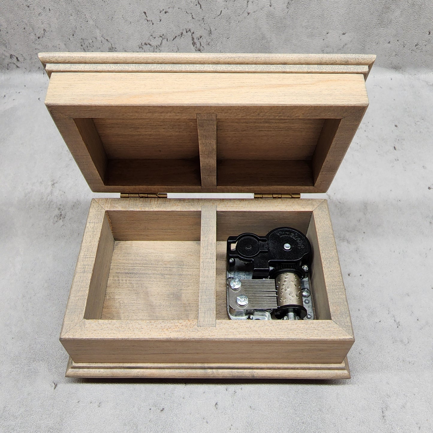 music jewelry box with open lid showing music box movement inside