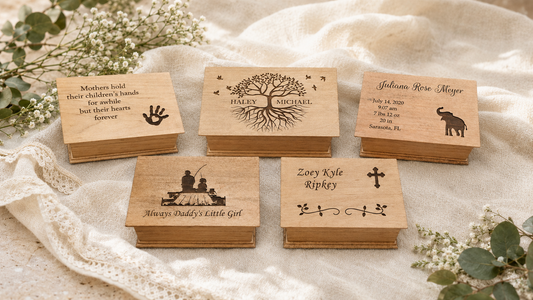 Five personalized wooden music boxes arranged on soft ivory linen in natural daylight.