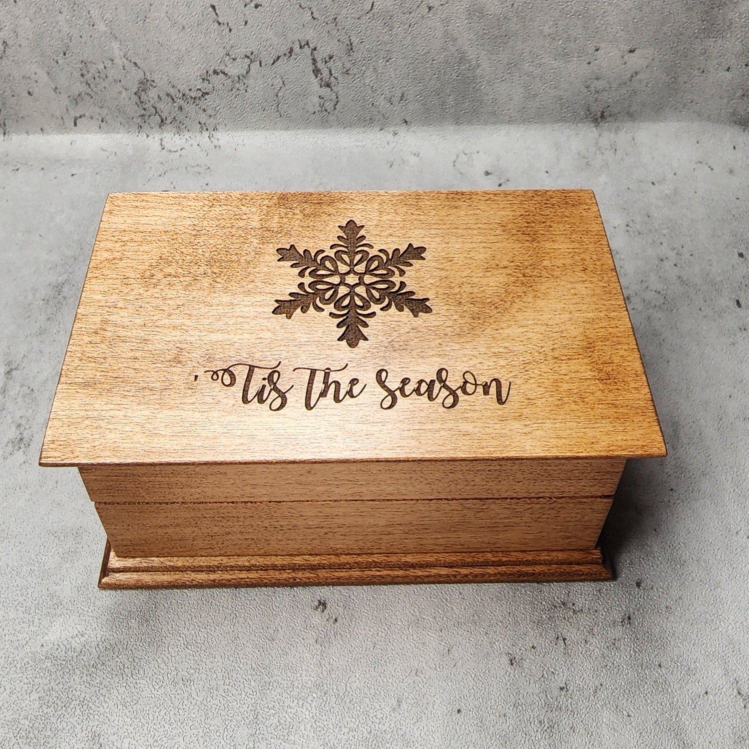 Handmade holiday keepsake box displayed beside festive greenery