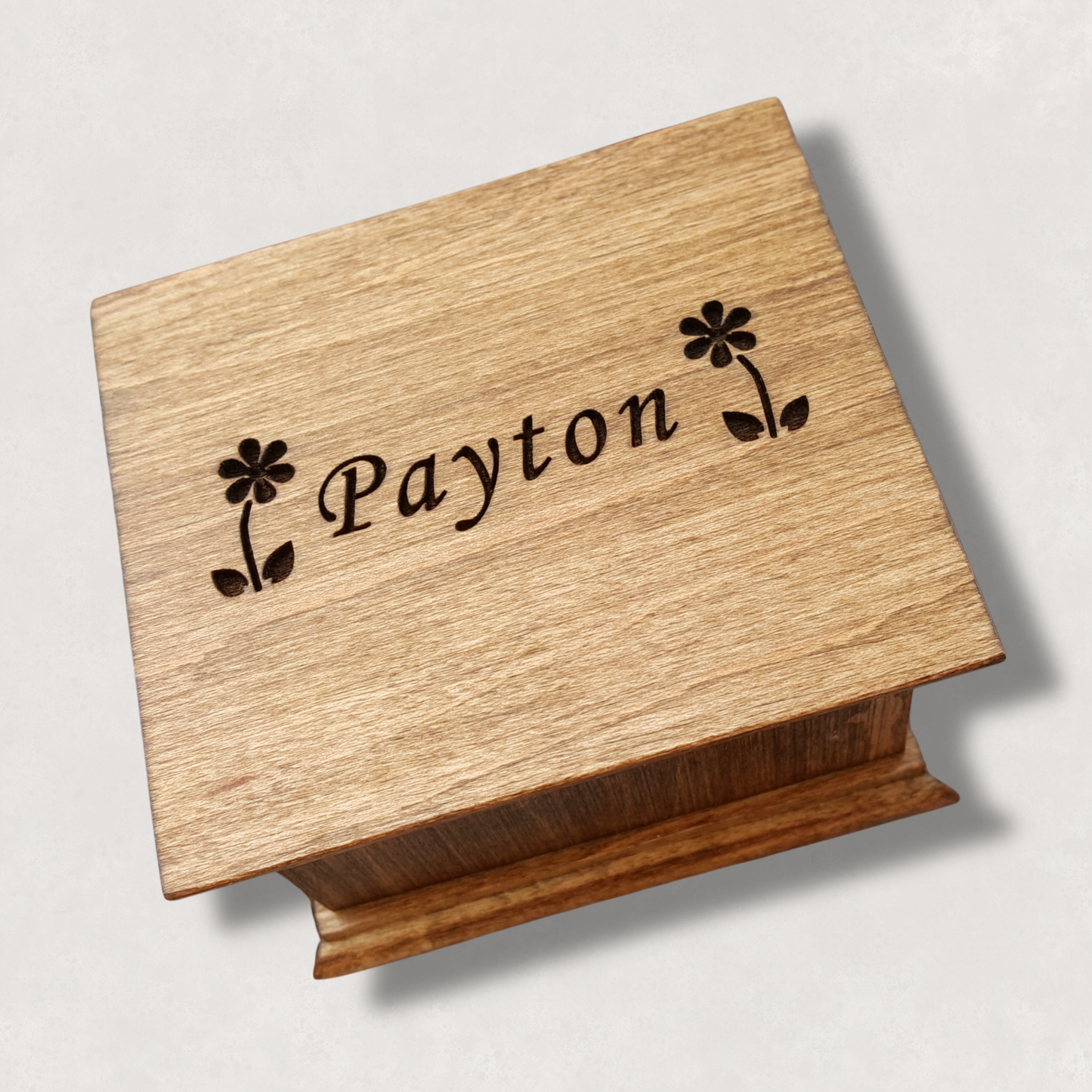 Wooden music box with 2 daisies and the name 'Payton' engraved on a light natural background