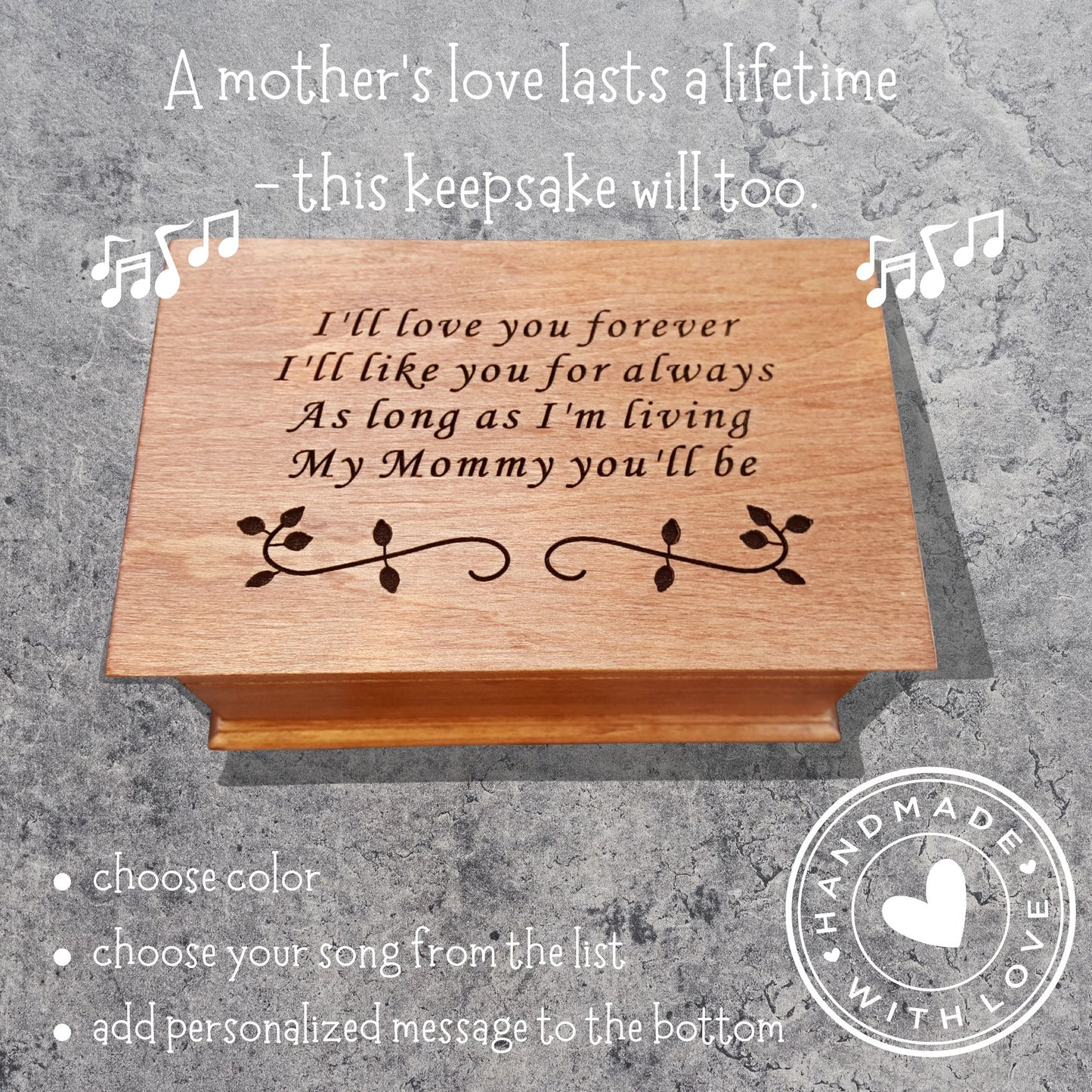 Handmade wooden music box engraved with the quote “I’ll love you forever, I’ll like you for always, as long as I’m living, my mommy you’ll be,” displayed on smooth river stones — sentimental personalized jewelry box for mom.