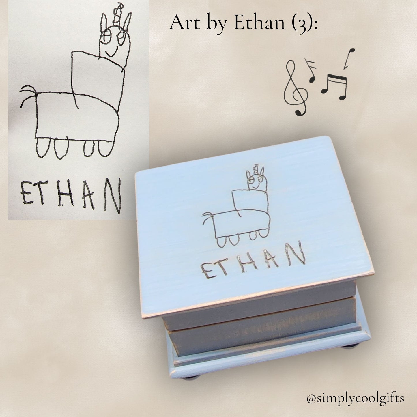 Light blue wooden music box with 'Ethan' engraving, next to child's drawing and musical notes.