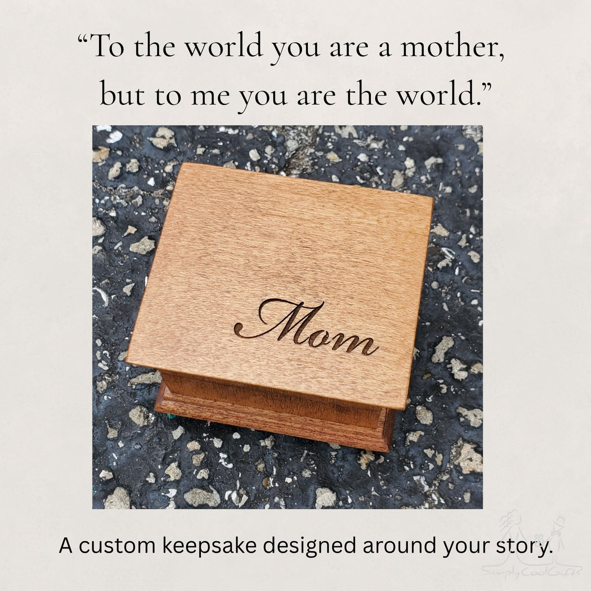 Wooden music box engraved with 'Mom' on a textured surface with a Mom quote above saying "To the world you are a mother, but to me you are the world."