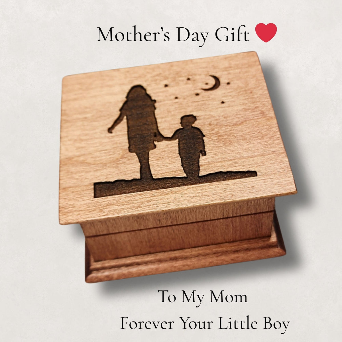 Wooden music box with engraved silhouette of a woman and son holding hands with moon and stars above them, suitable for Mother's Day gift.