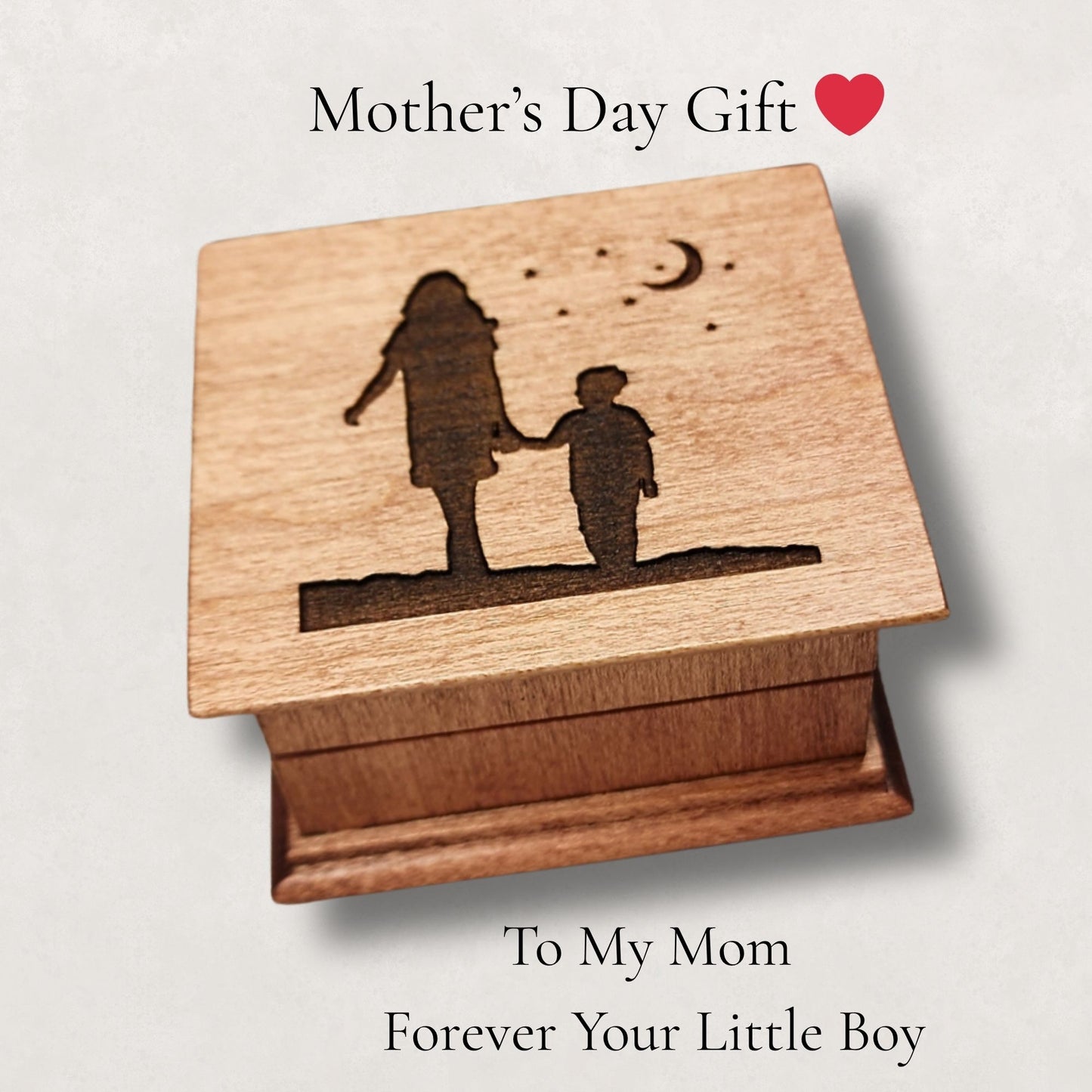 Wooden music box with engraved silhouette of a woman and son holding hands with moon and stars above them, suitable for Mother's Day gift.