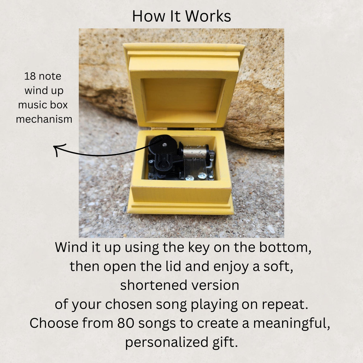 Wooden music box with the lid opened showing the 18 note wind up music box mechanism inside with a text explaining its mechanism and song selection.