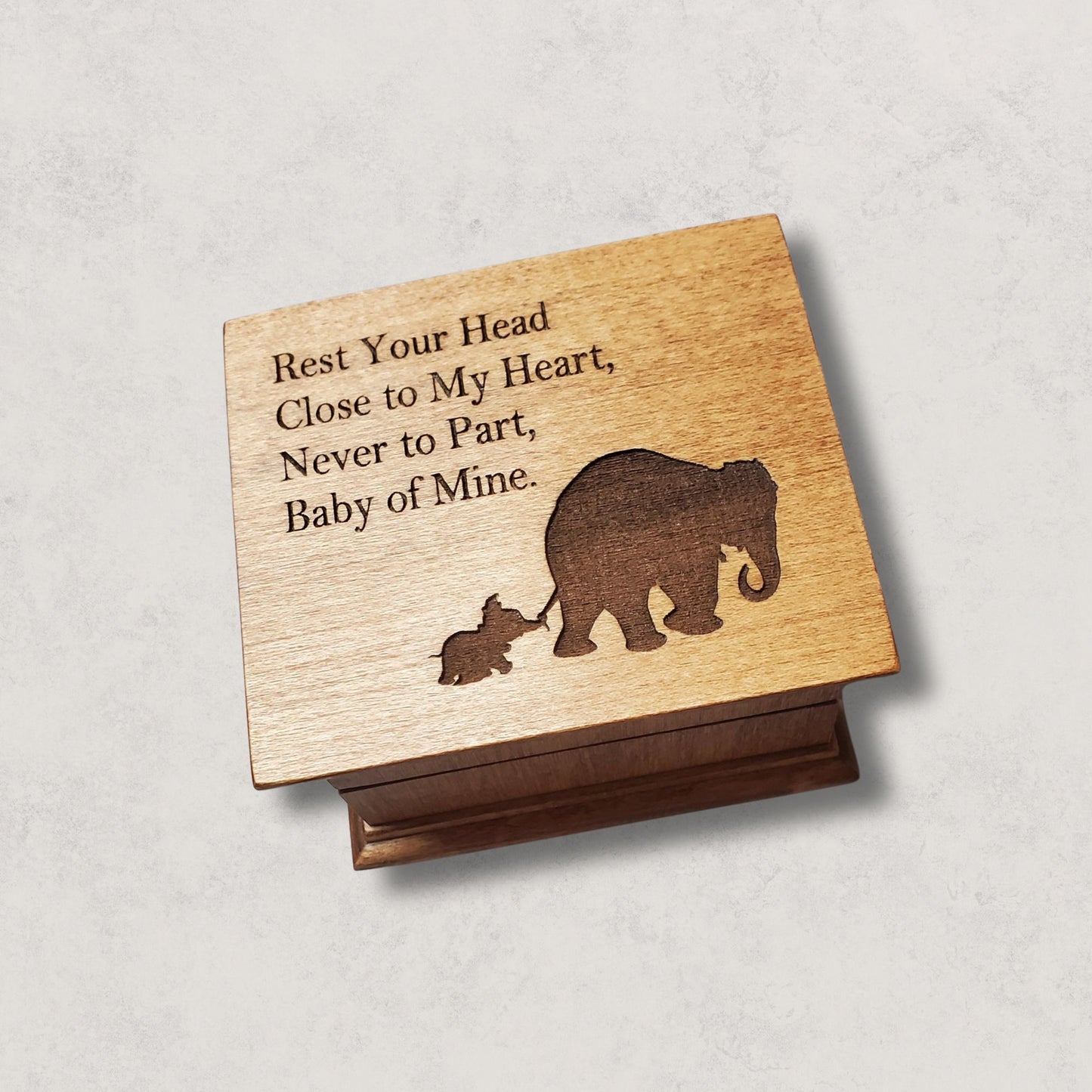 small wooden music box in chestnut with a momma and baby elephant silhouette engraved on the top along with the quote Rest Your Head Close to My Heart.... , choose the song Baby Mine and create a one-of-a-kind keepsake