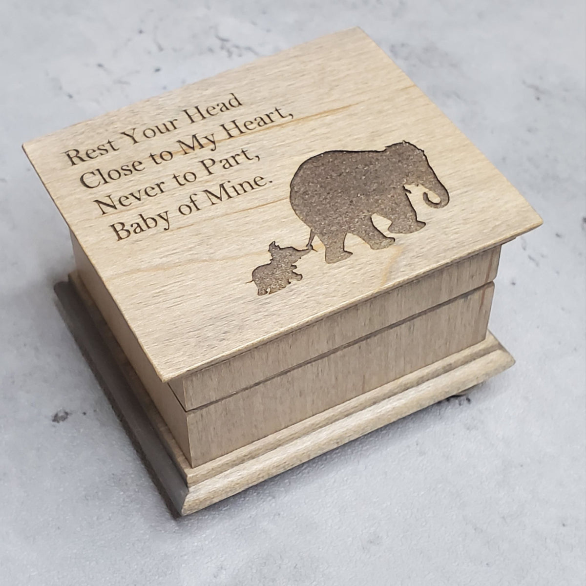 small wooden music box in gray with a momma and baby elephant silhouette engraved on the top along with the quote Rest Your Head Close to My Heart.... , choose the song Baby Mine and create a one-of-a-kind keepsake