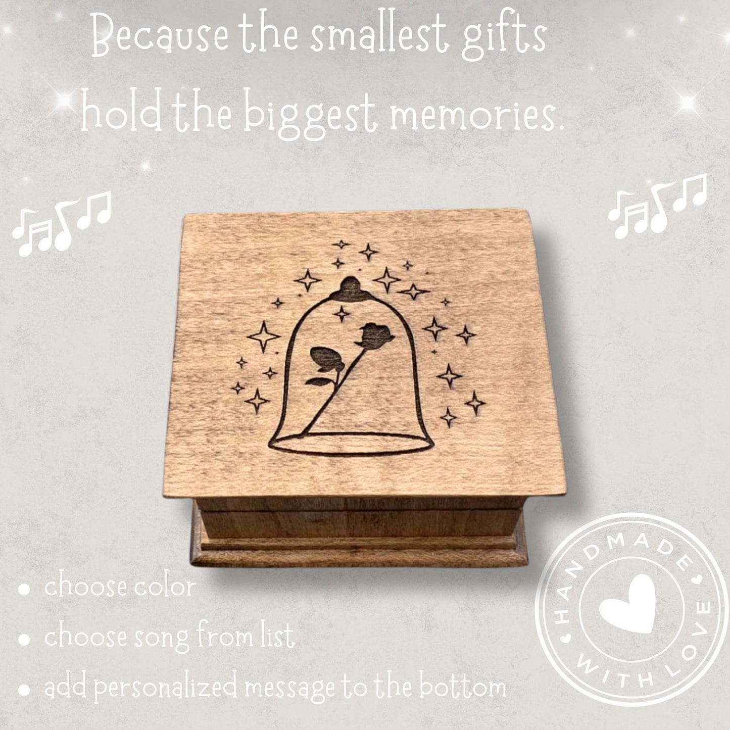 Small handcrafted wooden wind-up music box with engraved lid with rose under glass dome with stars surrounding it. 