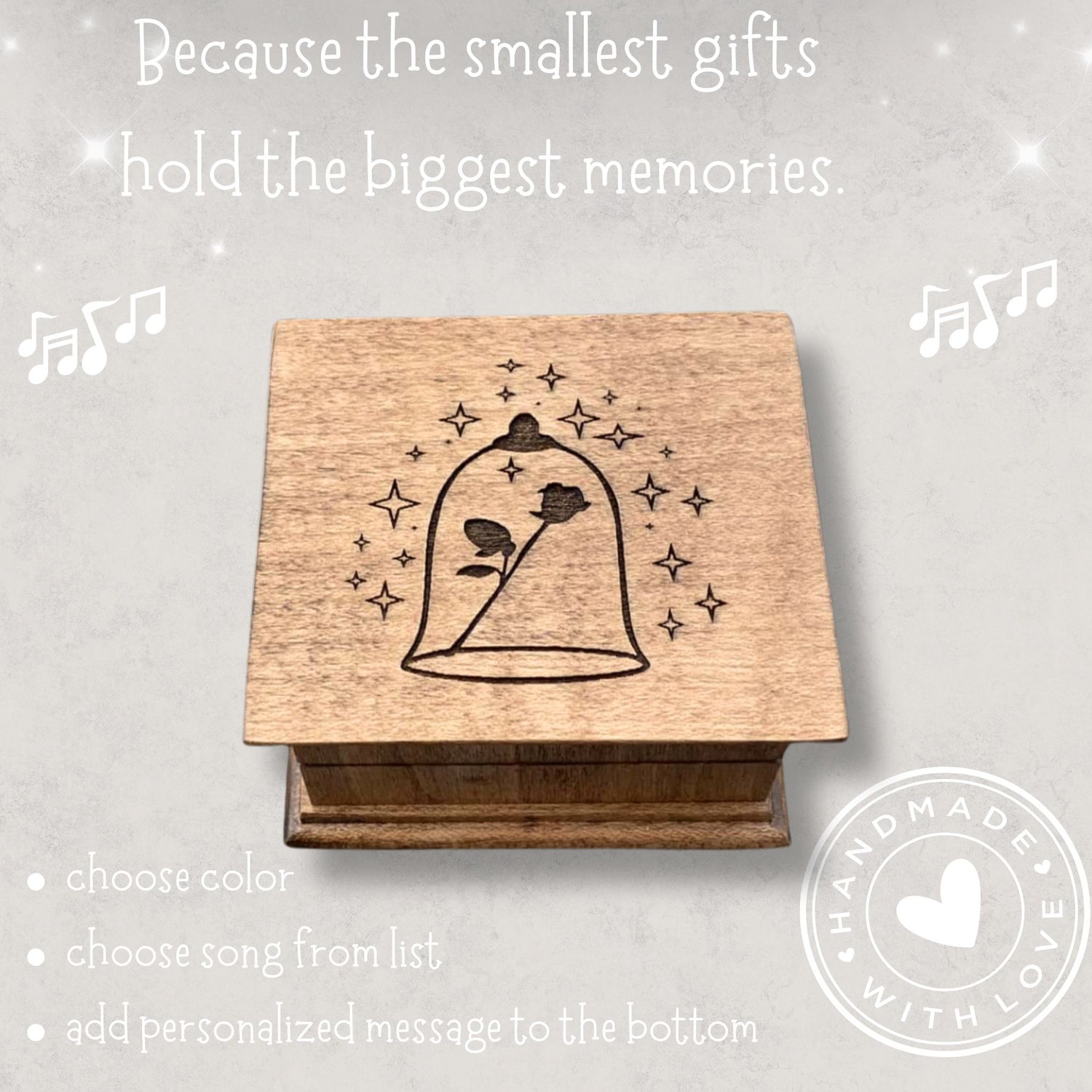 Small handcrafted wooden wind-up music box with engraved lid with rose under glass dome with stars surrounding it. 