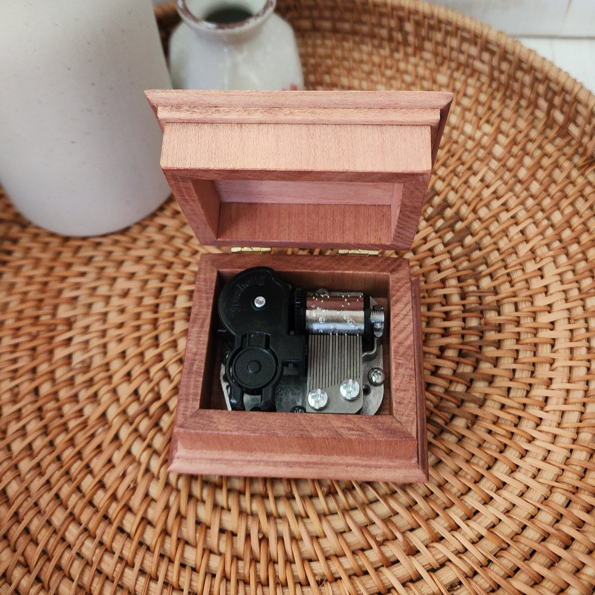 Wooden music box with the lid open showing the 18 note wind up music box mechanism