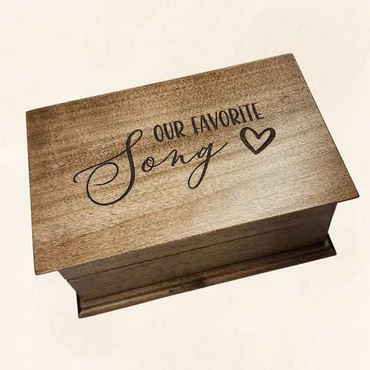 Music box with 'Our Favorite Song' engraving on a beige background