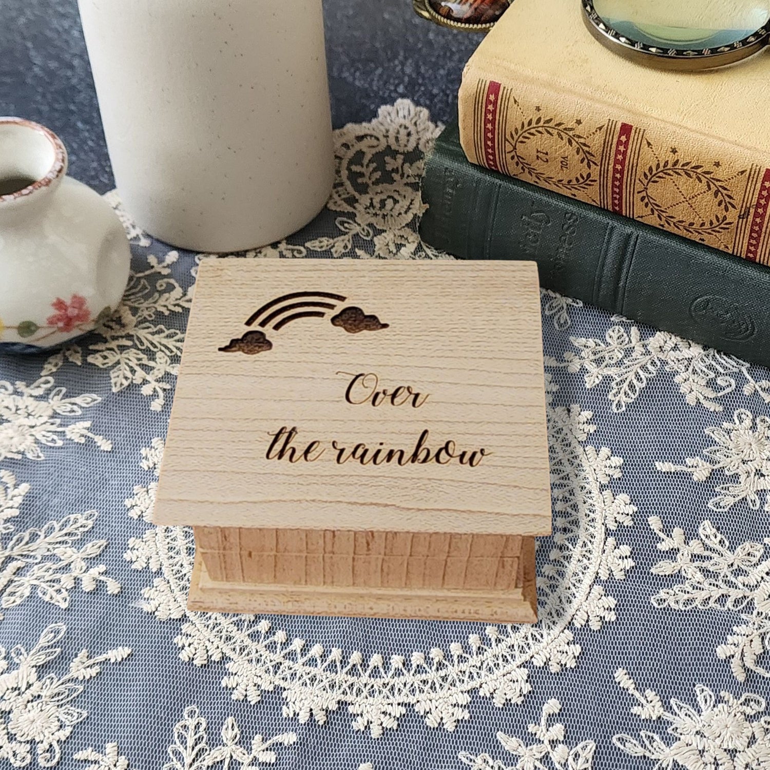 Small handcrafted wooden music box engraved with a rainbow and the words “Over the Rainbow"