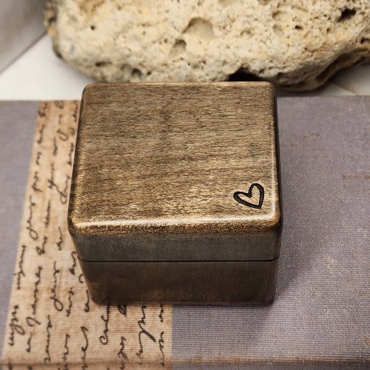 Handmade wooden ring box with engraved heart on top, shown closed, perfect for engagement or proposal.