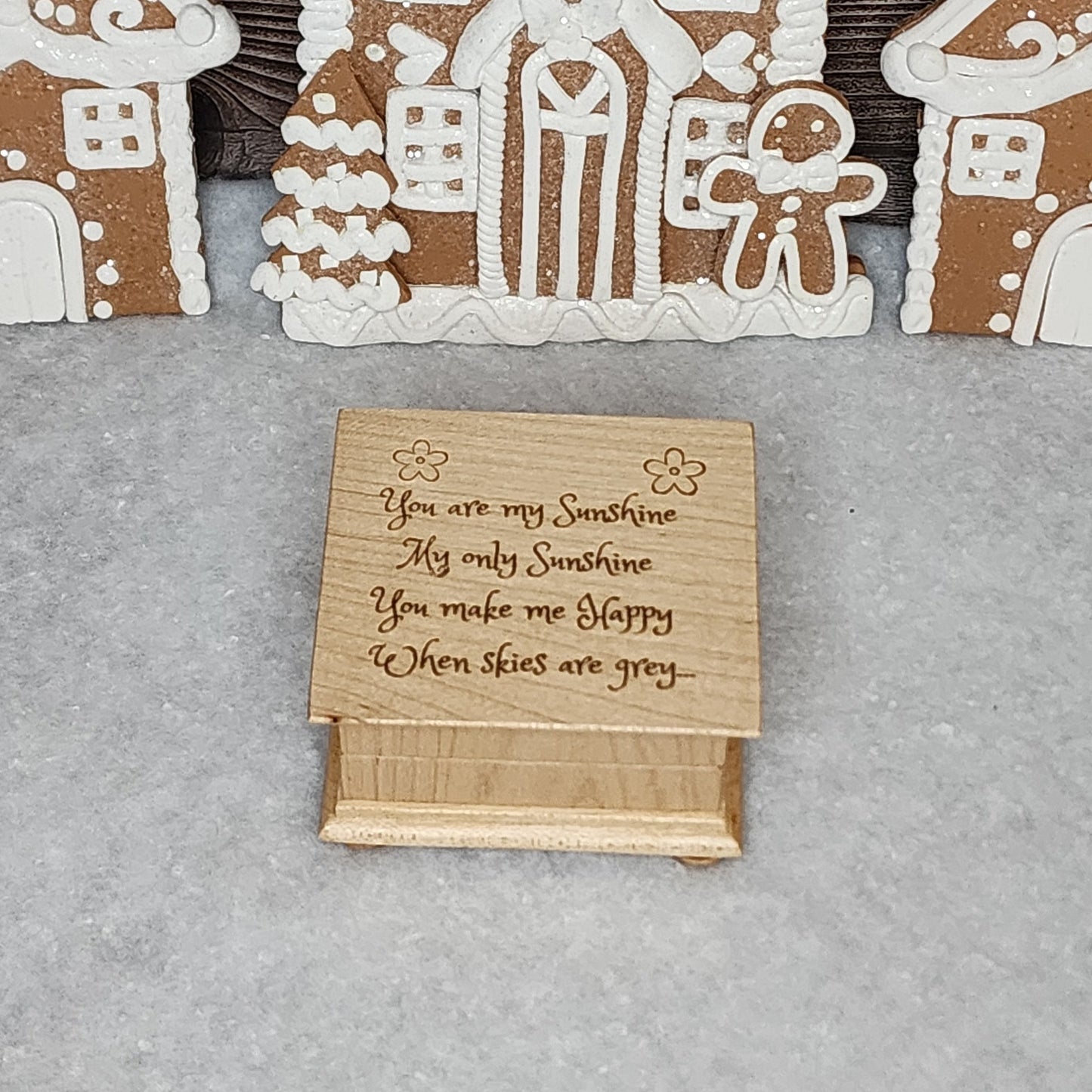 You are my sunshine engraved music box playing You are my sunshine in a winter snowy setting with gingerbread houses in the background