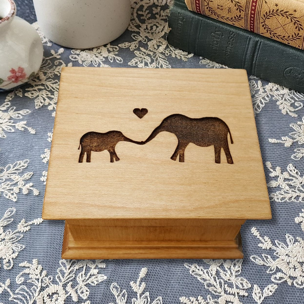 Personalized baby elephant music box handmade in Florida, engraved mom and baby elephant design, maple wood keepsake gift box on lace table setting