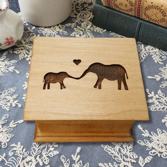 Personalized baby elephant music box handmade in Florida, engraved mom and baby elephant design, maple wood keepsake gift box on lace table setting