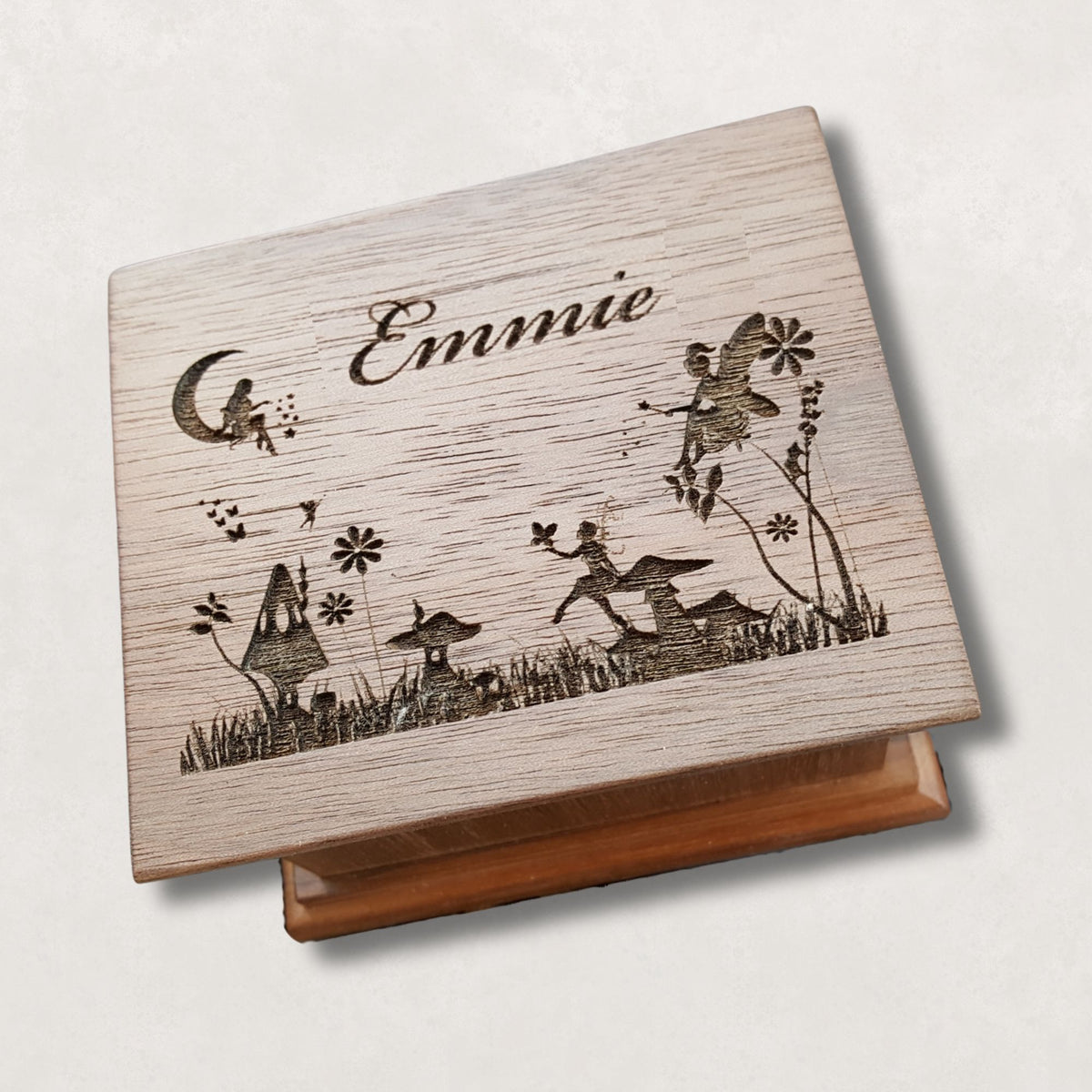 fairy realm engraved music box on a natural beige surface