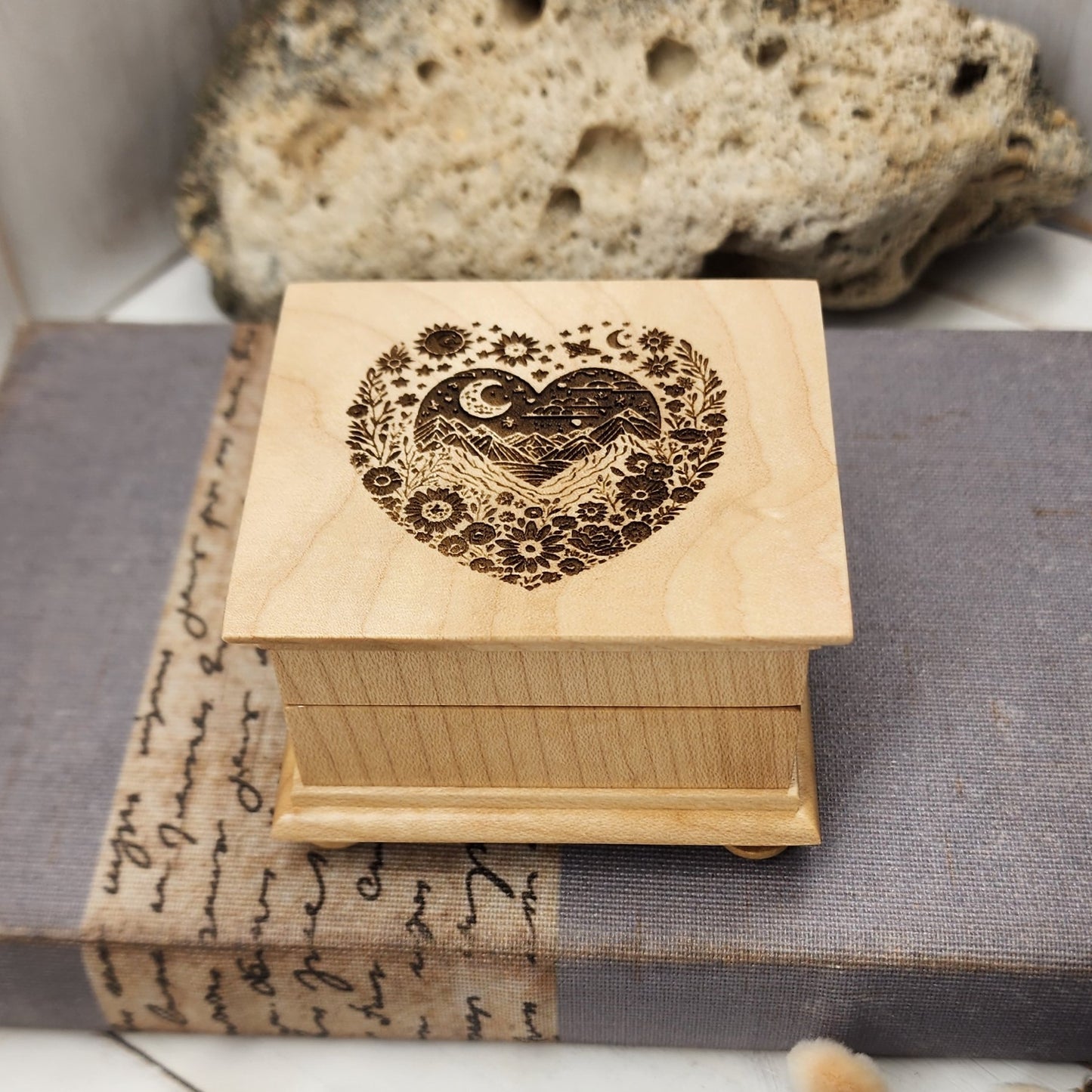 heart music box with a mountain design engraved inside the heart along with moon and stars, flowers and mountains, music box shop, music box store