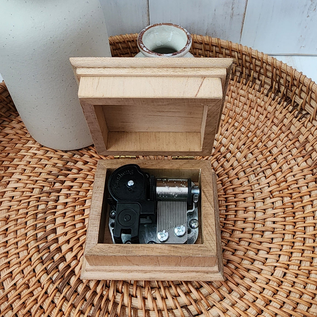 music box showing the lid open with the wind up music box mechanism inside 