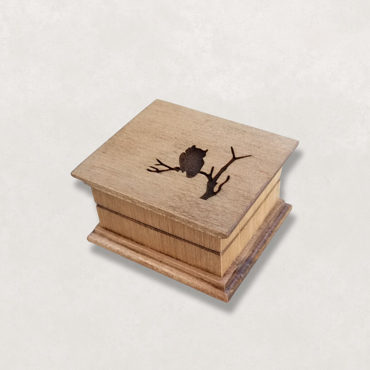 Wooden Handcrafted Music box with an owl design on a light gray background