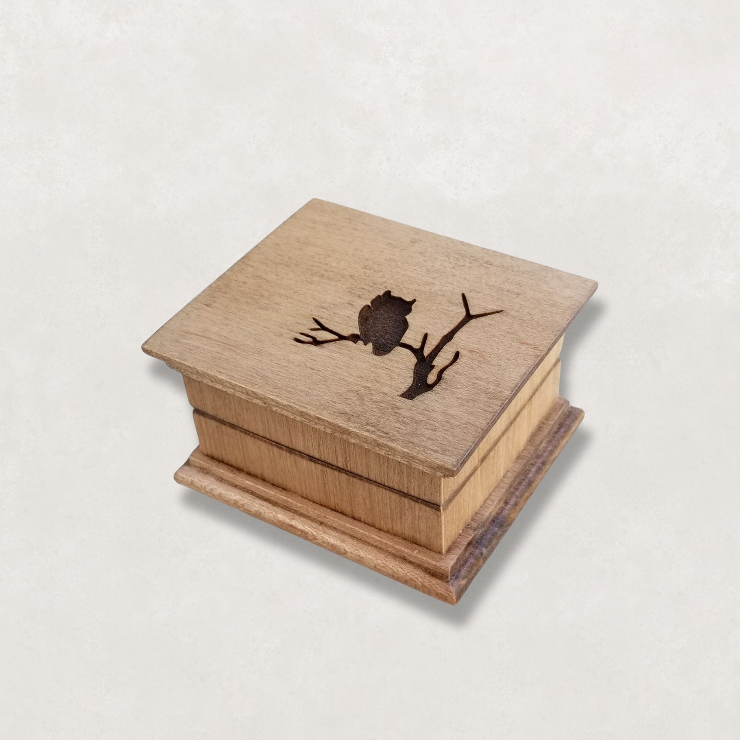 Wooden Handcrafted Music box with an owl design on a light gray background