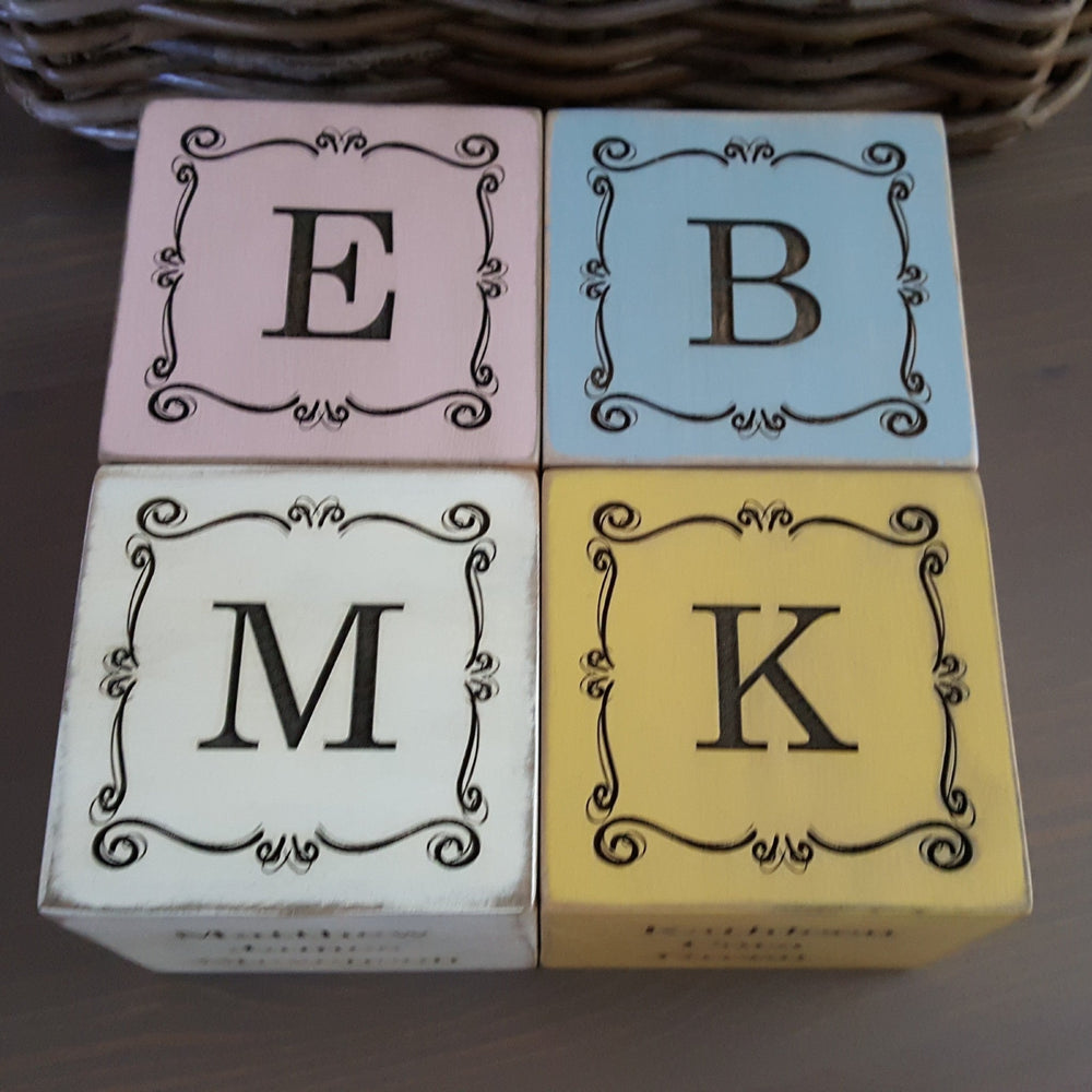 Four personalized wooden baby blocks with engraved initials