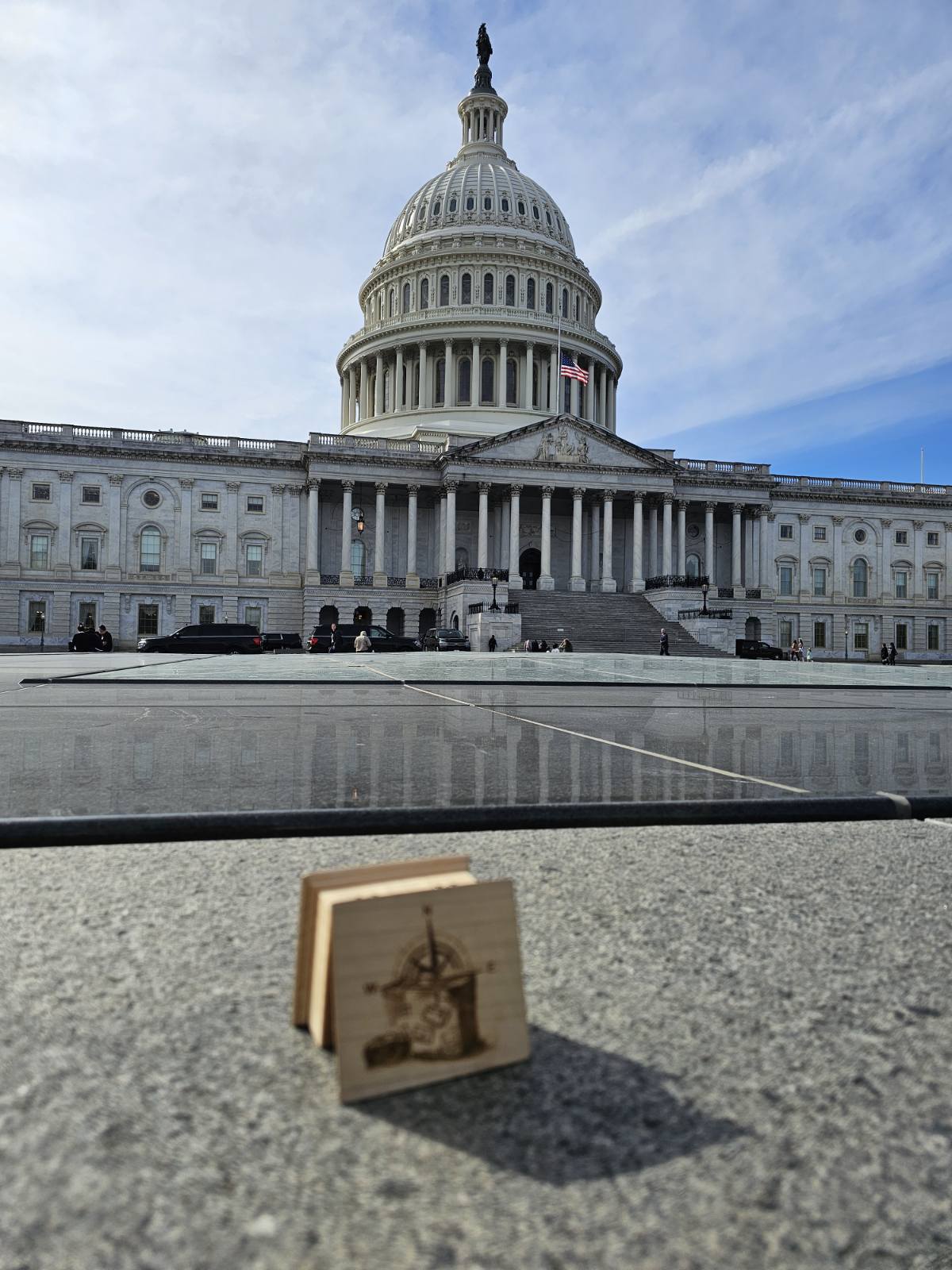 United States Capitol building with a small wooden music box model of the building in front.