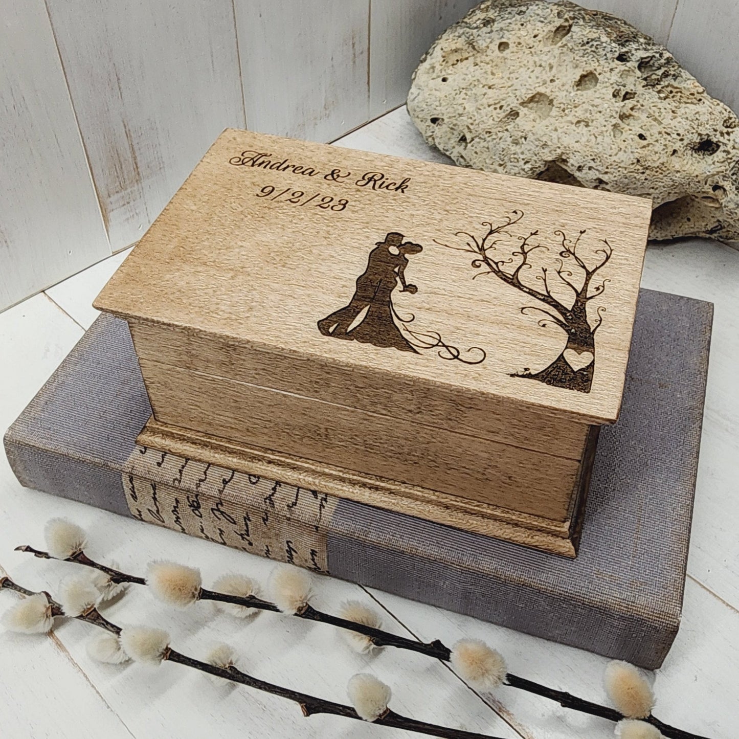 Wooden box with engraved design on a light wooden surface with decorative elements.