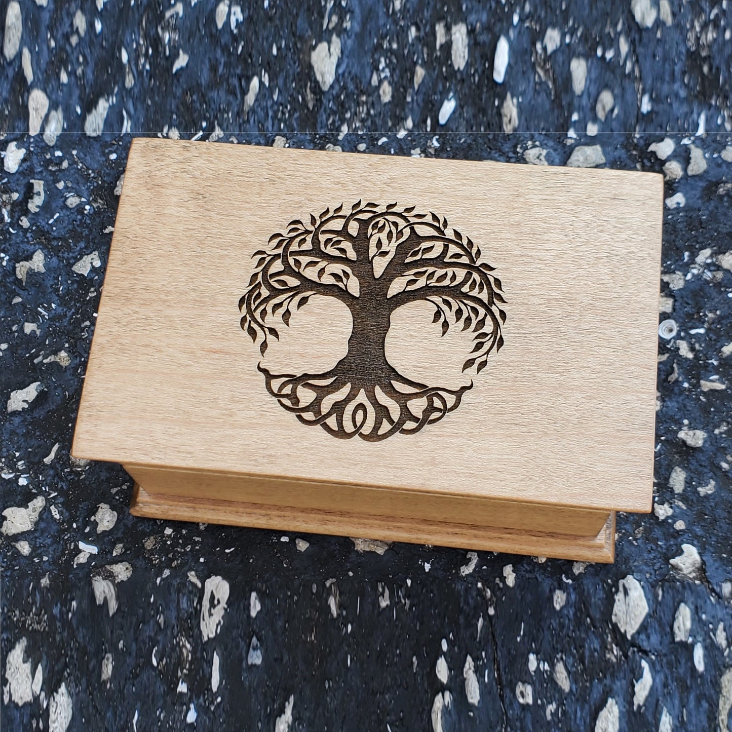 A wooden music jewelry box with a tree engraved on top, playing your song. Choose color
