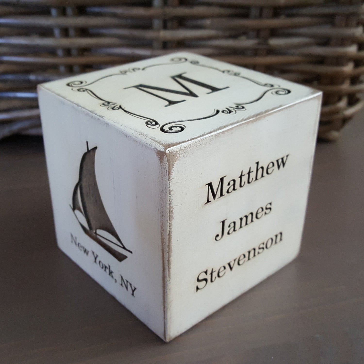 engraved baby cube in white showing a sailboat, name and monogram, perfect for nautical nursery