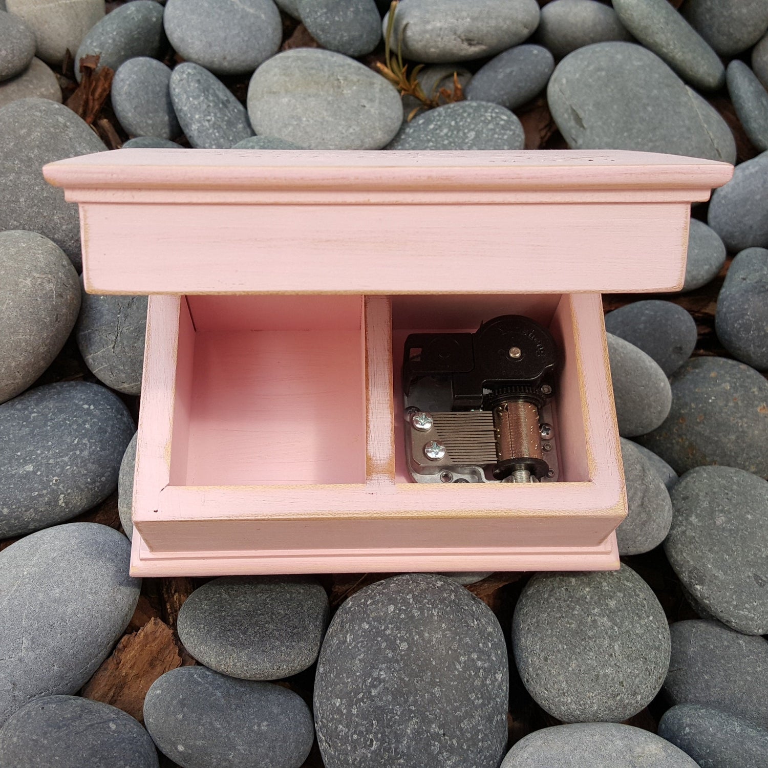 jewelry box in vintage pink, showing built in music box movement inside