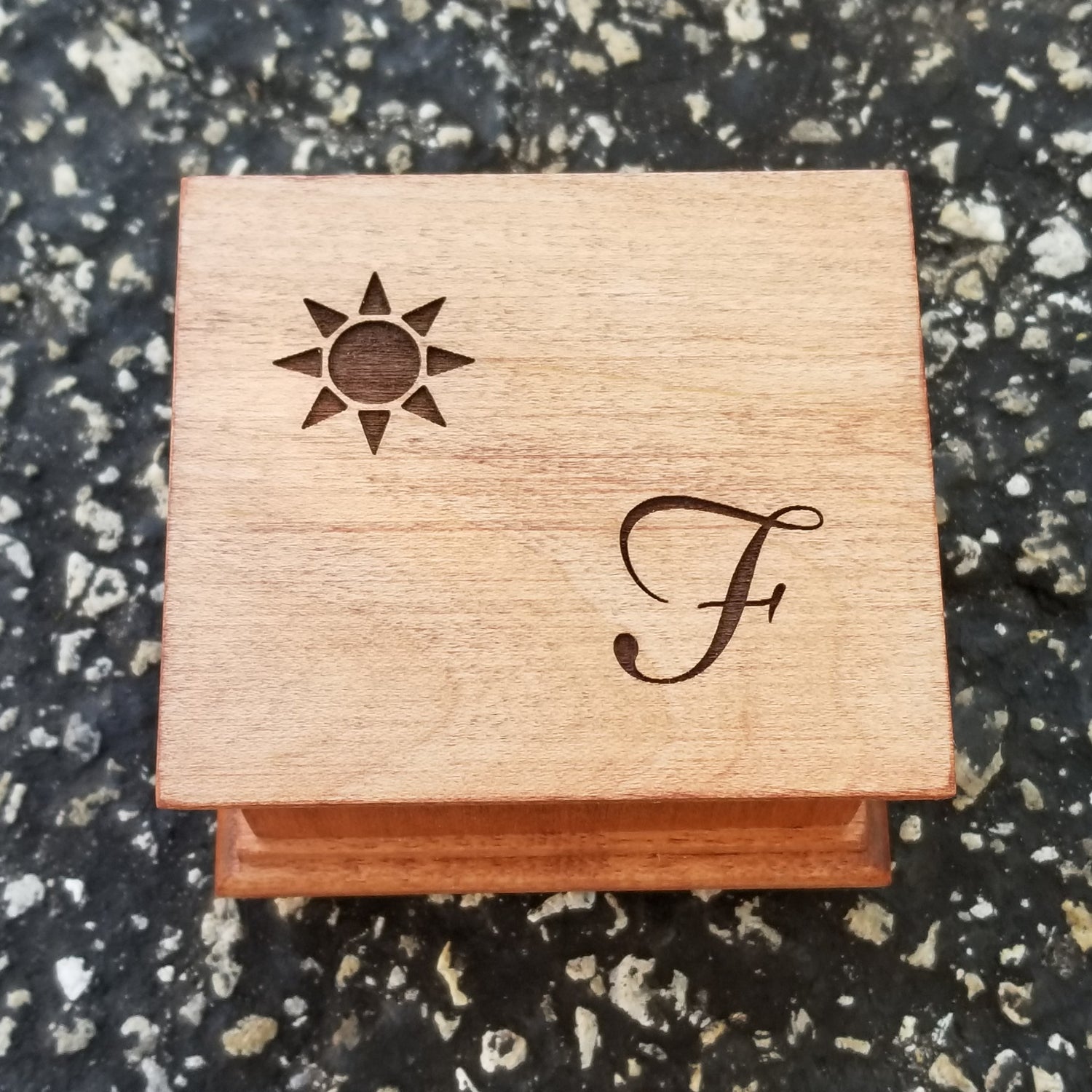 wood music box with a sun image and a monogram engraved on top, personalizing option