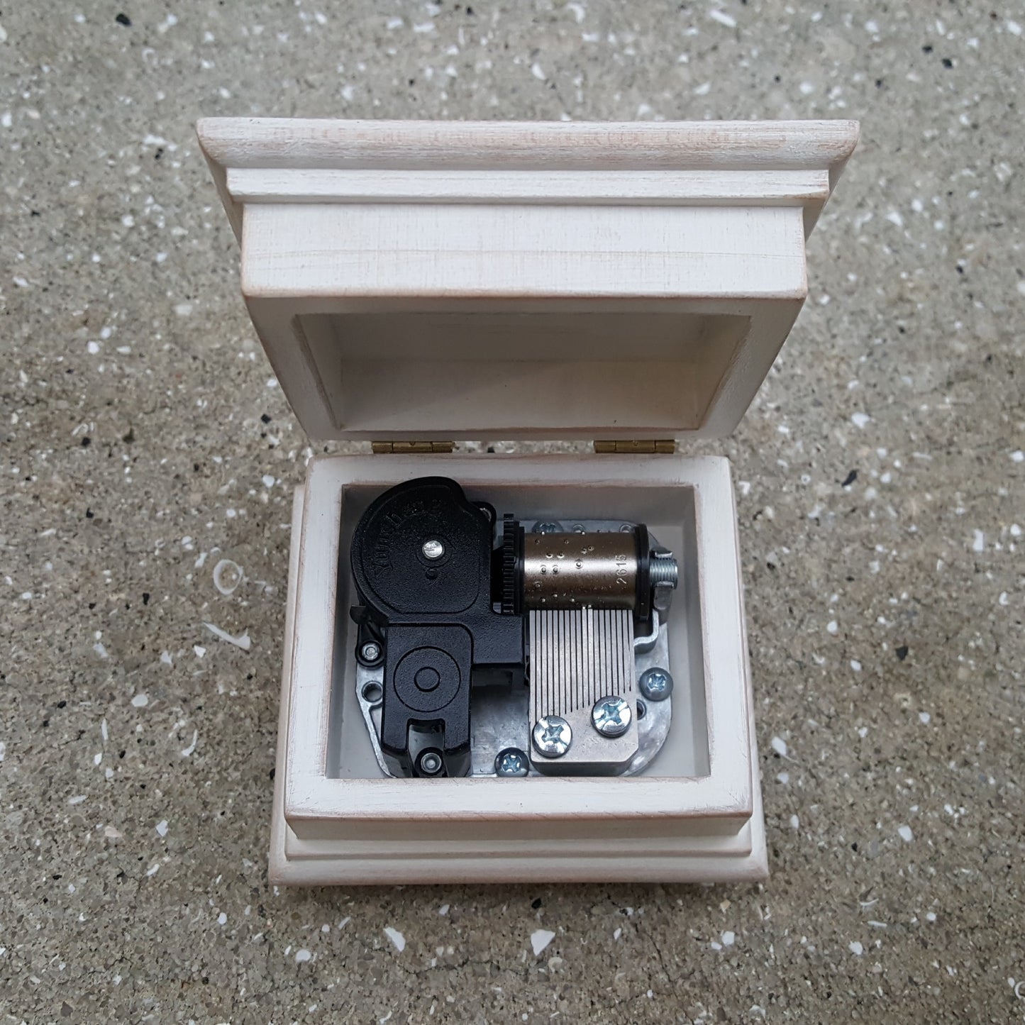 music box with open lid showing music box movement inside