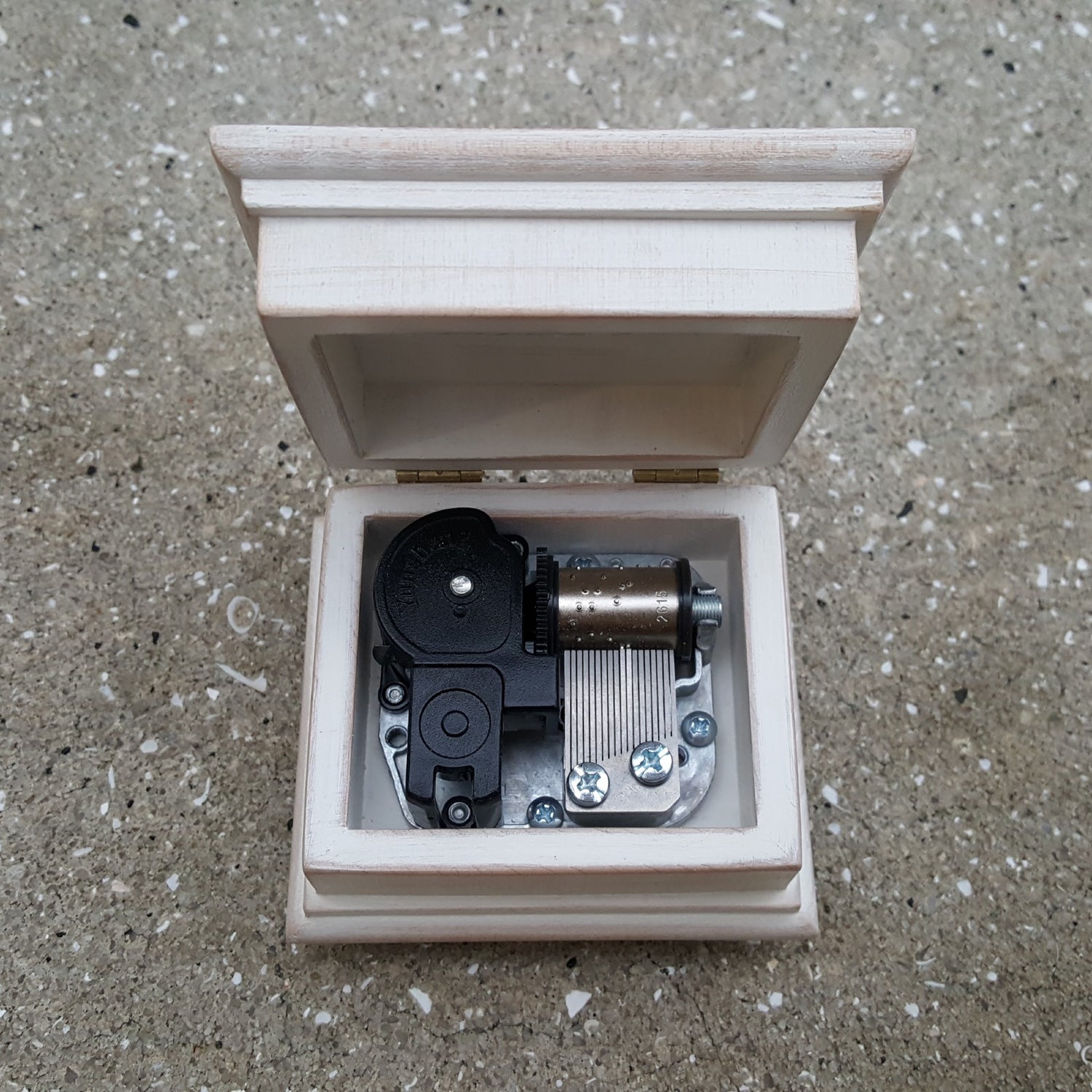 music box with open lid showing music box movement inside