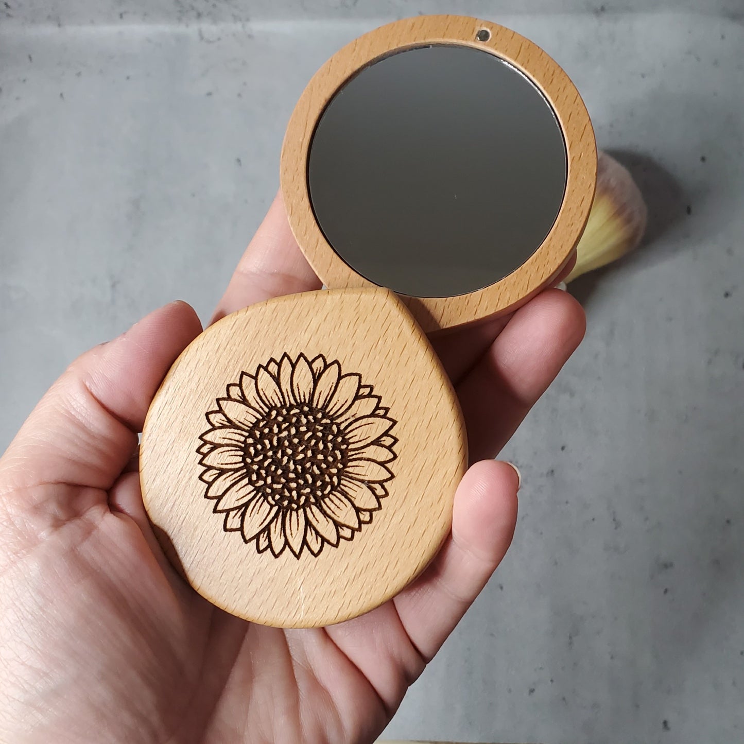 compact mirror with a sunflower engraved on the top, made of maple wood