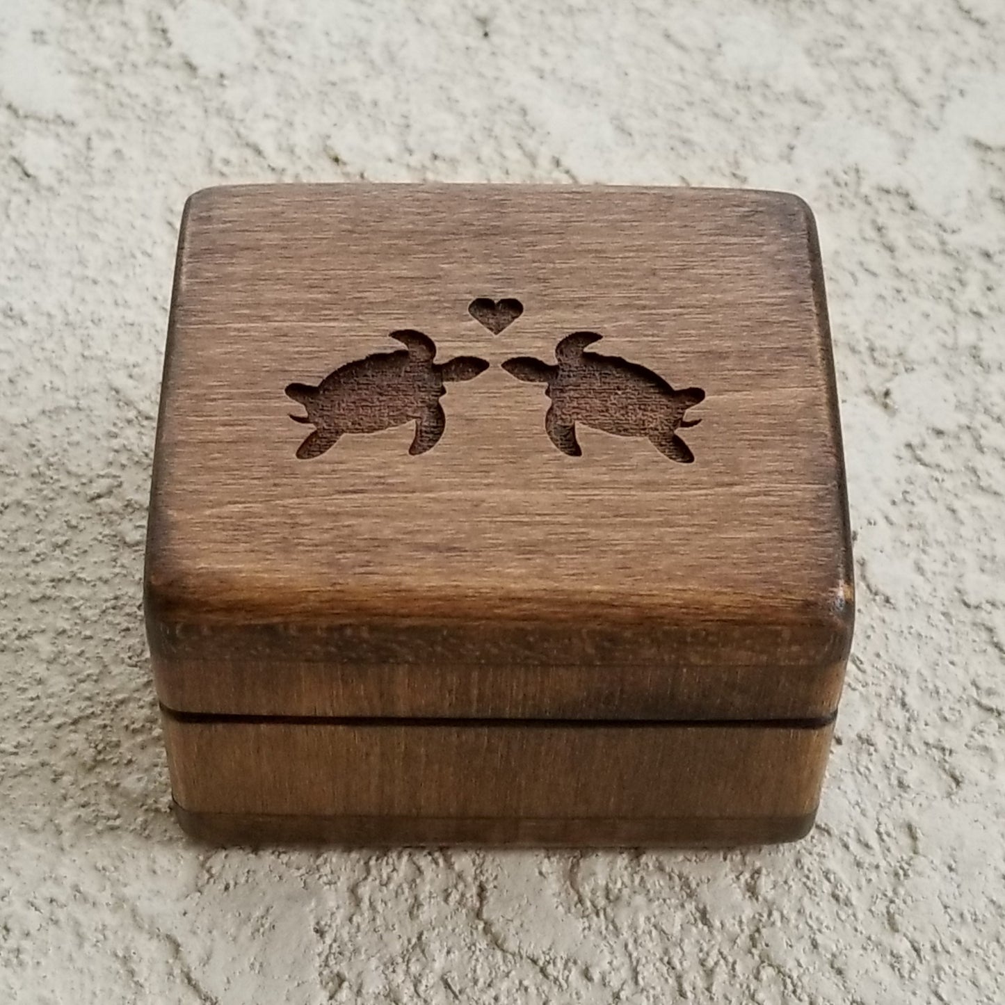 wooden ring box with turtles engraved on top